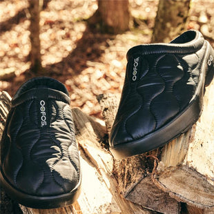 OOcoozie thermo black shoes on logs in the woods